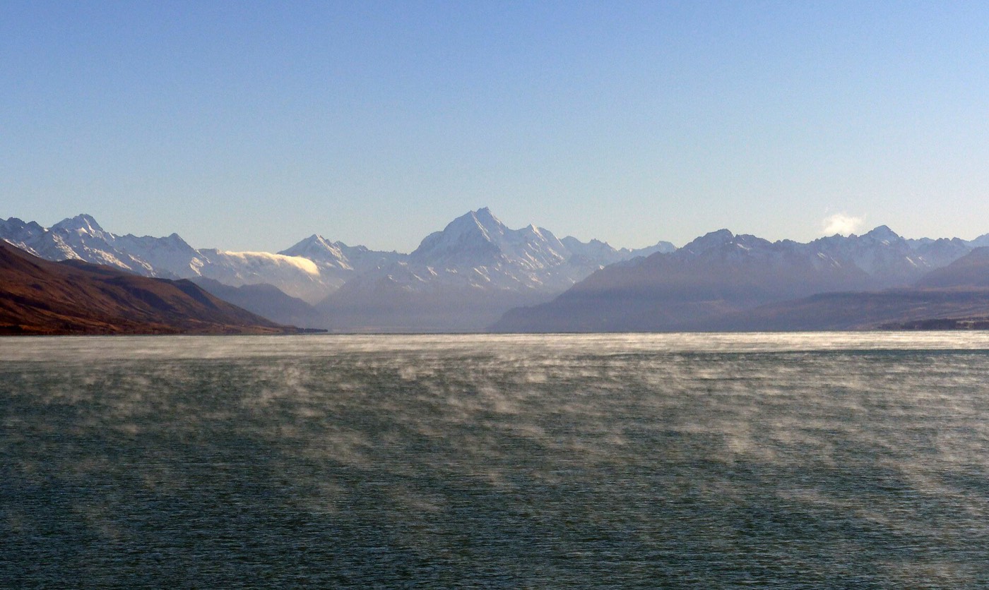 普卡基湖乳藍色的湖面，遠方是覆雪的庫克山與南阿爾卑斯山脈